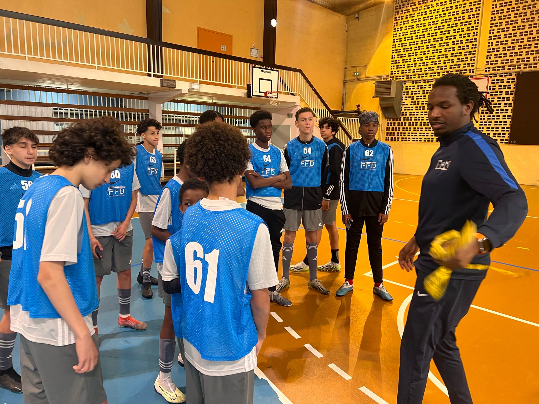 Image de jeunes joueurs souriant à la caméra avec leur entraîneur et la mascotte du club, un lion